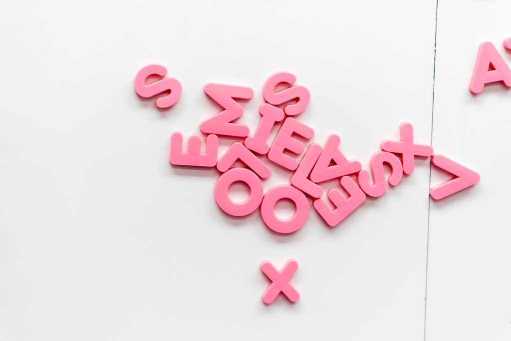Pink magnetic plastic letters on a white background
