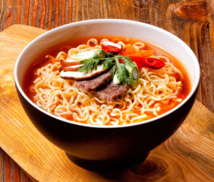 A black bowl of Shin Ramyun with beef and vegetables.