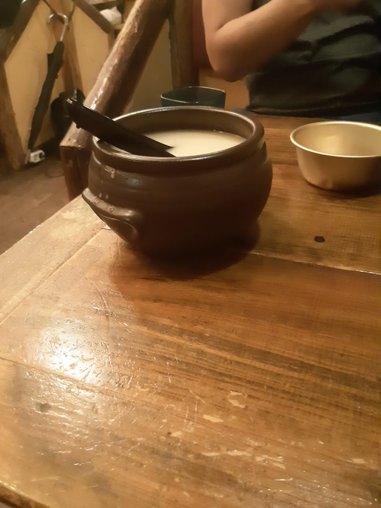 A bowl of makgeolli on a wooden table.